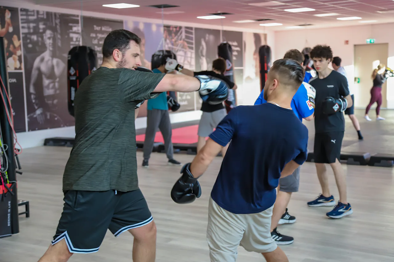 Partnerübung beim Boxtraining in der vollen Halle