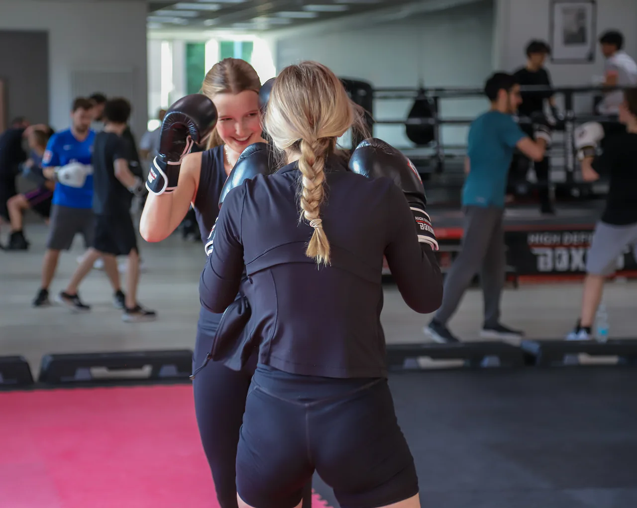 Trainerin korrigiert eine Boxtechnik in der Gruppe