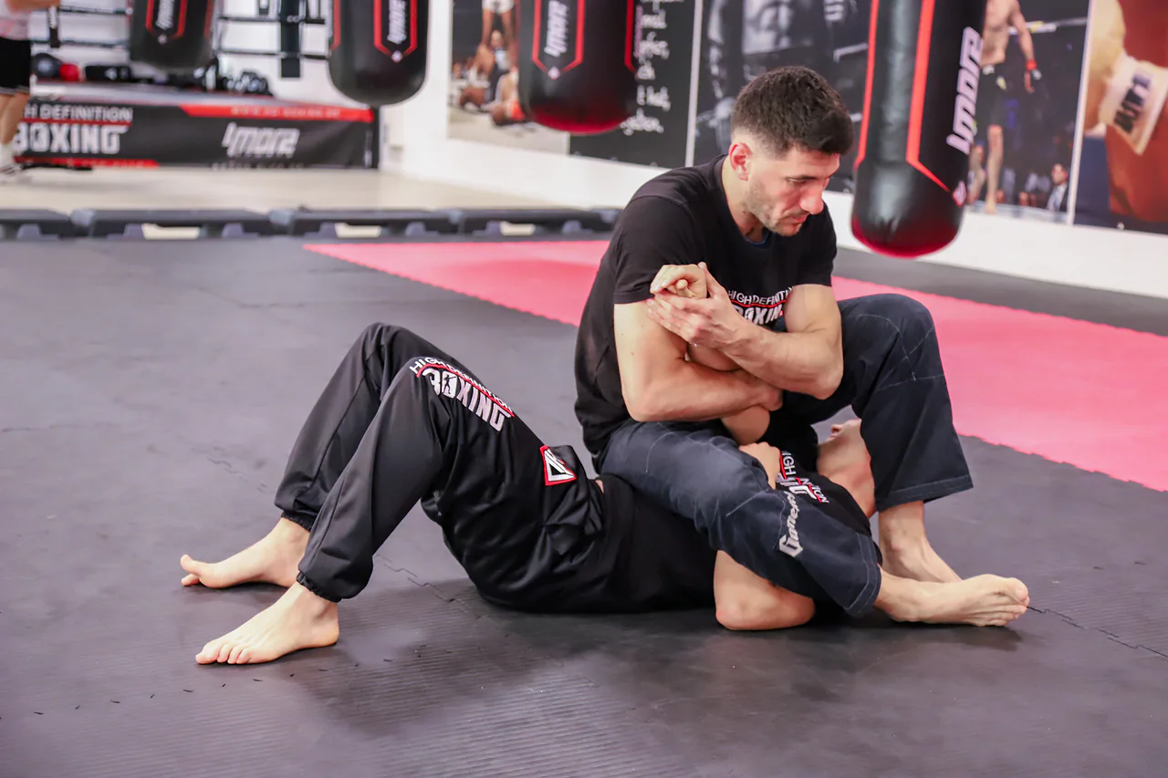 Zwei BJJ-Sportler arbeiten an einer Bodenposition